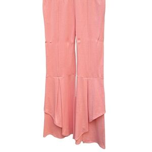 pair of pink bell bottom pants with an asymmetrical ruffle hem